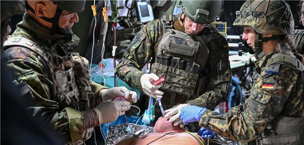 Ärzte in Uniform beim Intubieren einen verletzten Soldaten; die Puppe ist das Modell eines Patienten.