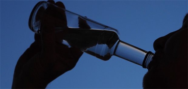 Suchtverhalten steigt nach Absetzen von GLP-1-RA wohl wieder an Ein Mann trinkt aus einer durchsichtigen Flasche.