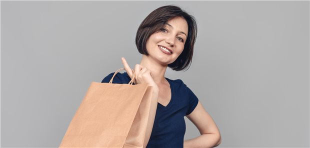 Frau mit brauner Einkaufstüte in der Hand