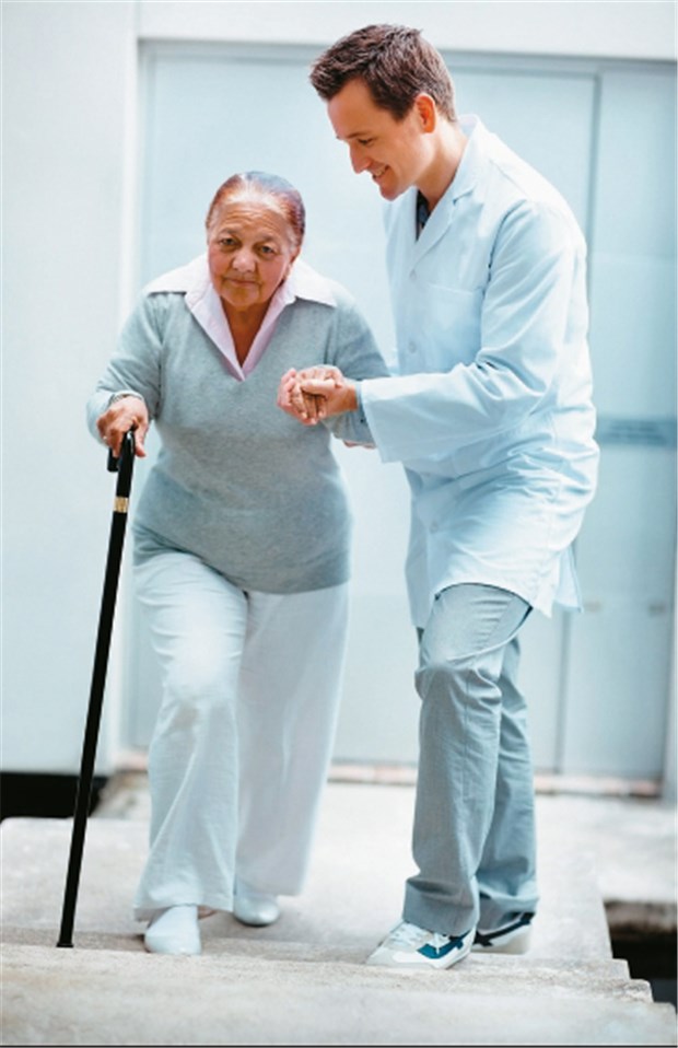 Physiotherapie plus Vitamin D mindern Stürze nach Fraktur Patientin übt Treppensteigen nach Hüftfraktur.