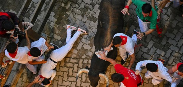 11.07.2025, Spanien, Pamplona: Teilnehmer treiben die Stiere von Jandilla am fünften Tag der Sanfermín-Festlichkeiten durch die Innenstadt. Foto: Miguel Oses/AP/dpa +++ dpa-Bildfunk +++