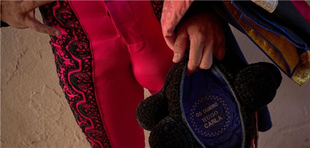 14.07.2025, Spanien, Pamplona: Ein Mitglied des Gefolges eines Stierkämpfers wartet, bevor er die Stierkampfarena während des San-Fermin-Festivals betritt. Foto: Miguel Oses/AP/dpa +++ dpa-Bildfunk +++