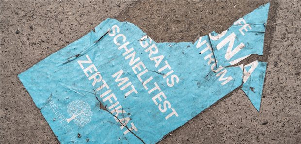 Ende freier Bürgertests: Stiftung warnt vor Chaos, MB vor mehr Infektionen Ein verwitterter Pfeil, der auf einem Gehweg in der Innenstadt liegt, weist den Weg zu einem Testzentrum, das gratis Corona-Schnelltest mit Zertifikat anbietet.