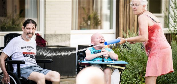 Abkühlung an heißen Tagen kann auch Spaß machen. Eine Pflegekraft sorgt sich im Innengarten des Pflegeheims Aafje De Vijf Havens in Rotterdam um ihre Schützlinge.