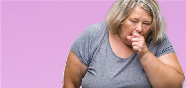 Symbolbild mit Fotomodell: Hustende Person mit Adipositas.