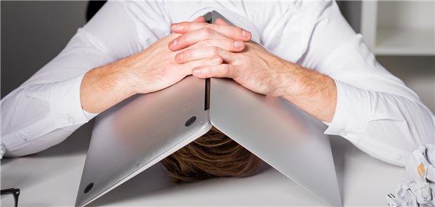 Arzt steckt seinen Kopf unter den Computer.