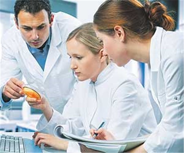 Ärztliche Weiterbildung ist besser als ihr Ruf Ärzte tauschen sich über eine Laborprobe aus. Teamgeist lässt Ärzte in Weiterbildung über den Arbeitsstress hinwegsehen.
