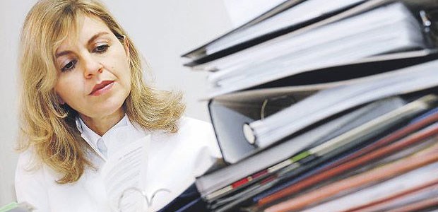 Qualitätskontrolle reicht nicht aus Ärztin beim Aktenstudium: Qualitätssicherung ist ein wahrer Zeitfresser, aber es führt kein Weg an ihr vorbei.