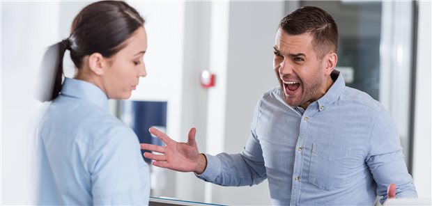 Aggressiver Mann vor Frau