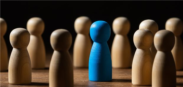 Aufnahmen einer Gruppe von Holzfiguren mit einer deutlich hervorgehobenen blauen Figur.