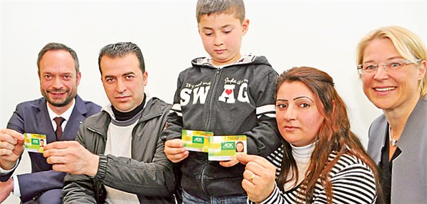 Streitpunkt Gesundheitskarte Amer Ahmed, seine Frau Antiya und Sohn Mohamed erhielten in Kiel aus den Händen von Landesgesundheitsministerin Kristin Alheit (SPD, rechts) und AOK-Chef Tom Ackermann (links) elektronische Gesundheitskarten überreicht.