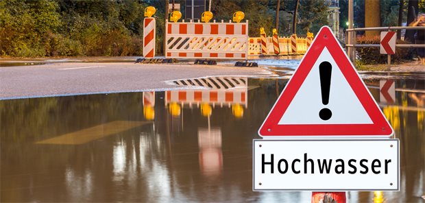 Zi-Umfrage: Die meisten Praxen haben keinen Notfallplan für Krisensituationen Hochwasserwarnschild vor übergelaufenem Fluss.
