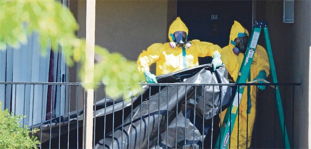 Ebola-Fall in Dallas schürt Angst Angestellte einer Reinigungsfirma verhängen die Eingangstür zum Apartment, in dem sich der Ebola-Patient in Dallas aufgehalten hat.