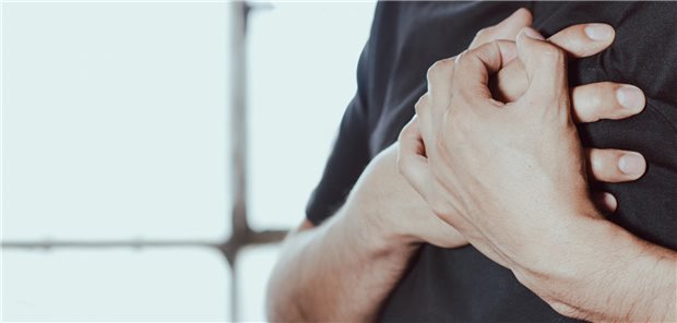 Mann greift sich an Brust.