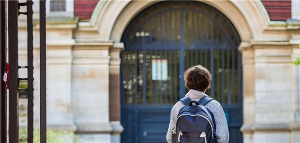 Junge vor einer Schule