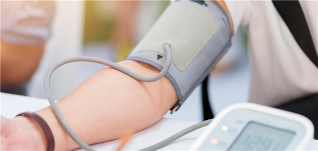 Ein Arzt misst den Blutdruck eines Patienten mit unkontrollierter Hypertonie.