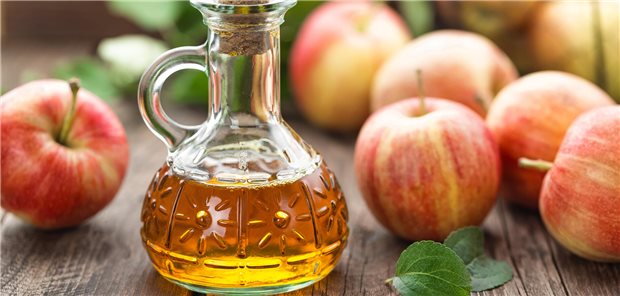 Äpfel und eine Flasche Apfelessig