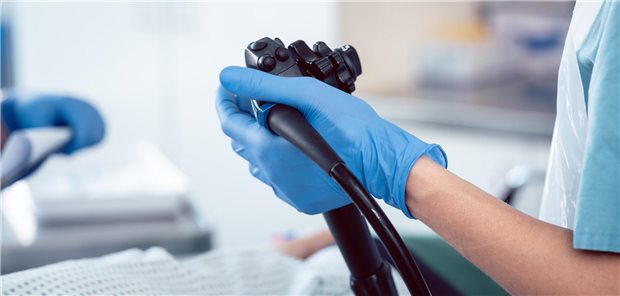 Ein Arzt hält das Endoskop während der Durchführung einer Koloskopie.