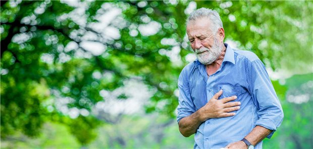 Älterer Mann fasst sich an die linke Brust, Herzschmerzen