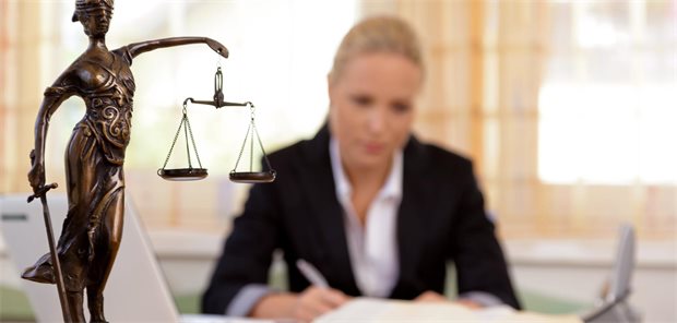 Statue einer Justitia steht auf dem Tisch einer Rechtsanwältin