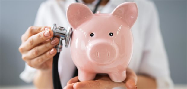Eine Ärztin untersucht ein Sparschwein.