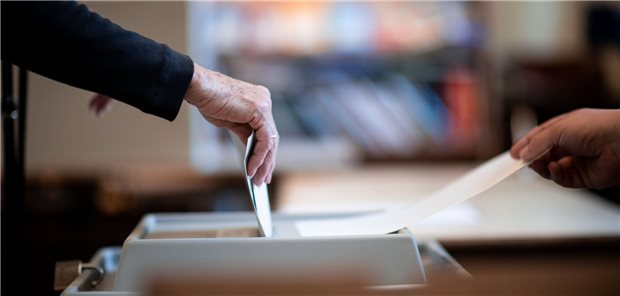 Eine Frau wirft ihren Stimmzettel in ein Wahlurne in einem Wahllokal.