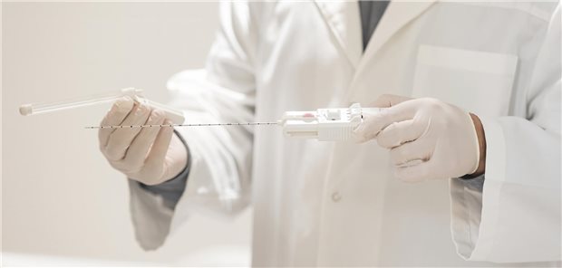 Arzt bereitet Gerät zur Entnahme einer Gewebeprobe der Prostata vor.