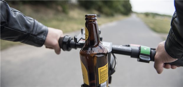 Promillegrenze? Nutzer von E-Scootern oft ahnungslos Ein E-Scooter-Fahrer ist mit einem alkoholischen Getränk im Flaschenhalter am Lenker unterwegs.