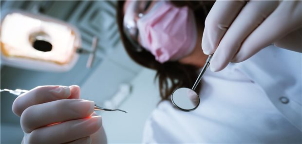 Zahnarzt mit Instrumenten von unten.