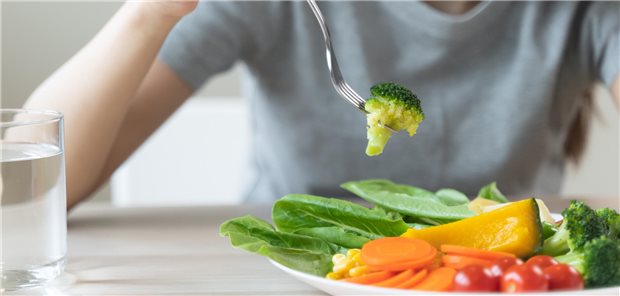 Ein Mann isst Gemüse auf einem damit prall gefüllten Teller.