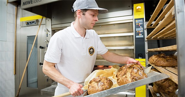 Karottenbrot für besseres Trinkwasser Bäckermeister Matthias Engel legt in seiner Bäckerei mehrere Grundwasserschutzbrote in ein Regal.