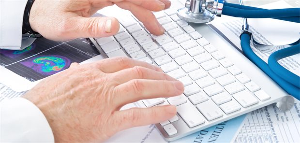 Arzt tippt auf einer Tastatur eines Computers