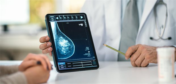 Ein Arzt zeigt einer Frau auf seinem Tablet einen Scan ihrer Brust.