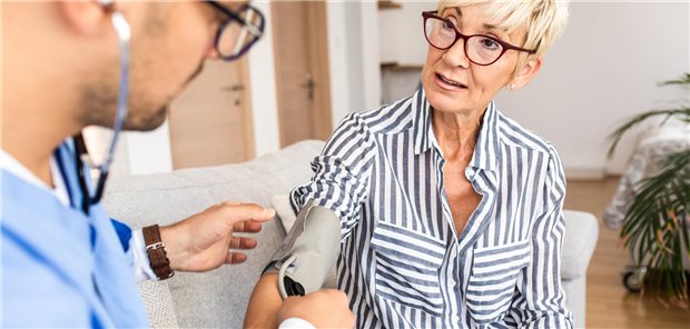 Hausbesuch: Ein Arzt misst den Blutdruck bei einer Dame zuhause.