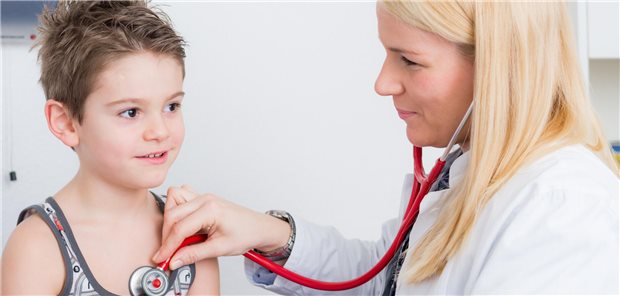 Eine Ärztin horcht einen Jungen ab.