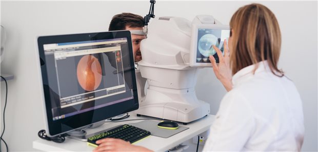Männlicher Patient hat eine Augenuntersuchung, bei der seine Netzhaut mithilfe eines digitalen Netzhautscanners untersucht wird.