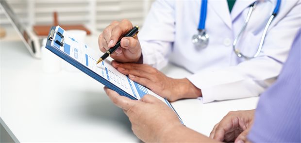 Ein Arzt geht zusammen mit seinem Patienten einen Fragebogen durch.