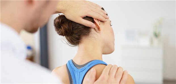 Ein Physiotherapeut behandelt eine Patientin mit Nackenschmerzen.