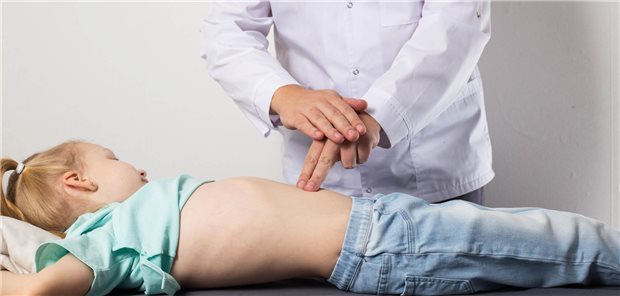 Ein Chirurg untersucht und diagnostiziert den Unterleib eines siebenjährigen Mädchens mit Bauchschmerzen um zu klären, ob bei diesem eine Blinddarmentzündung vorliegt.