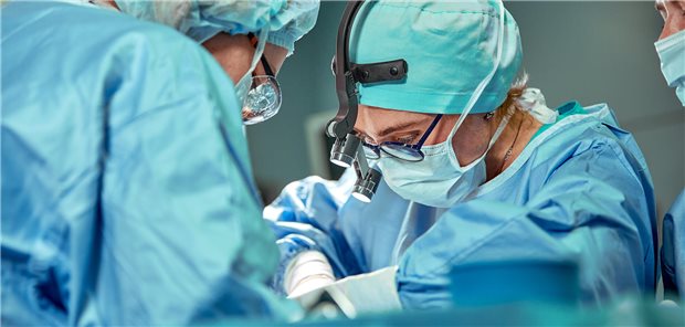 Eine Gruppe von Chirurgen behandlen einen Patienten auf dem Operationstisch.