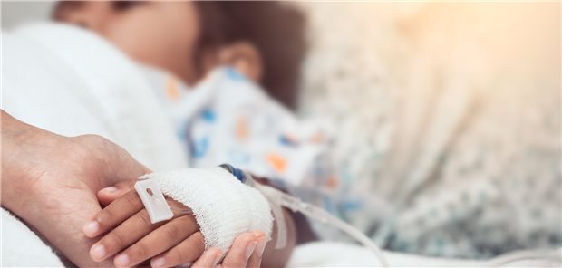 Eine Mutter hält die Hand ihres Kindes, das über einen Zugang im Handrücken eine Infusion erhält.