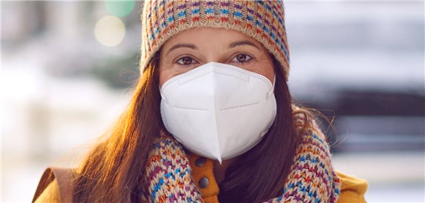 Frau trägt MNS in Schneeumgebung: Einige Fachleute sehen das Ende der Corona-Pandemie mit dem Winter kommen.