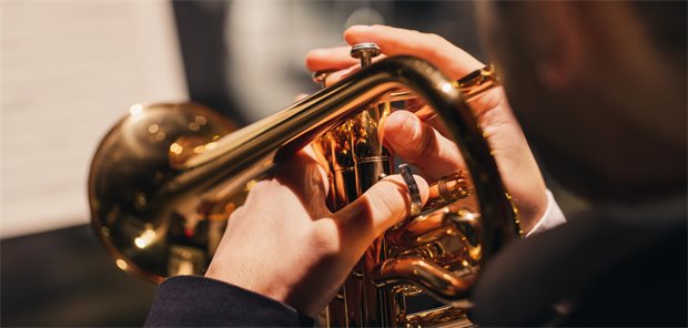 Blick über die Schulter eines Trompeters, der ein Konzert spielt.