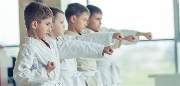Kind mit Autismus: Welche Sportarten stärken die Motorik am besten? Vier Jungs machen Karate.