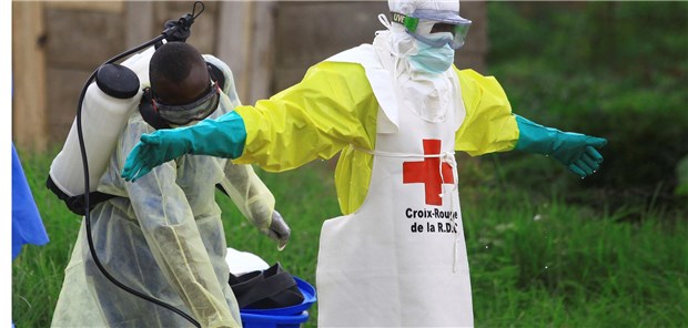 300 Ebola-Erkrankte im Kongo Beni, Kongo: Ein Mitarbeiter des Gesundheitsamtes sprüht nach einem Einsatz in einem Ebola-Behandlungszentrum Desinfektionsmittel auf einen Mitarbeit des Roten Kreuzes.