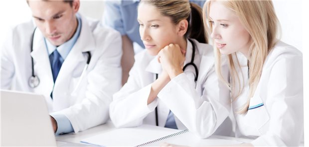 Mehrere Ärzte schauen auf eien Laptop
