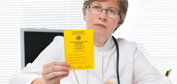 Eine Ärztin hält ein Impfbuch in der Hand.