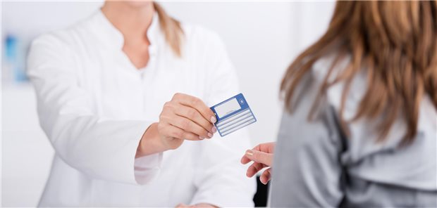 Ärztin gibt Patientin eine Gesundheitskarte