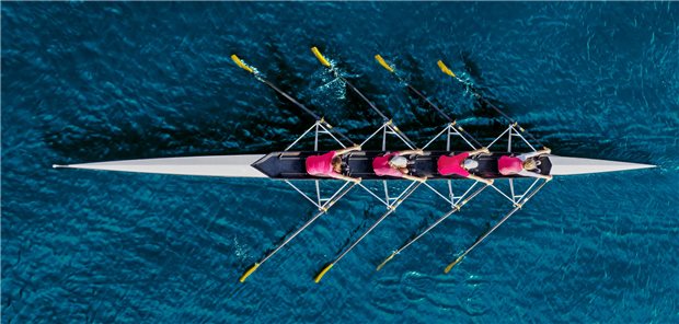 Women’s rowing team on blue water, top view