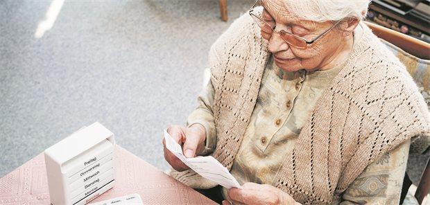 Eine ältere Frau liest einen Beipackzettel